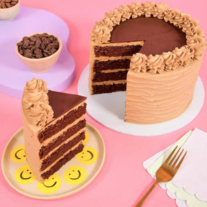 Vegan Chocolate Cake by Crumbs & Doilies with four layers of moist chocolate sponge and vegan buttercream icing.